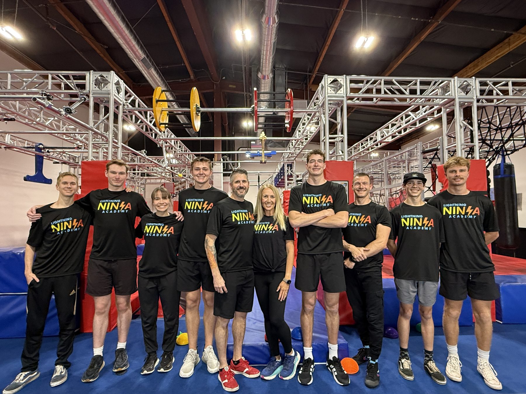 The full Lightning Ninja Academy coaching team standing together on the gym floor in Roseville